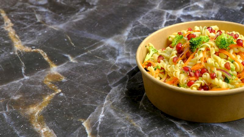 Vier wei&szlig;e Schalen mit verschiedenen Reissorten auf einem rot-beigen Tuch.